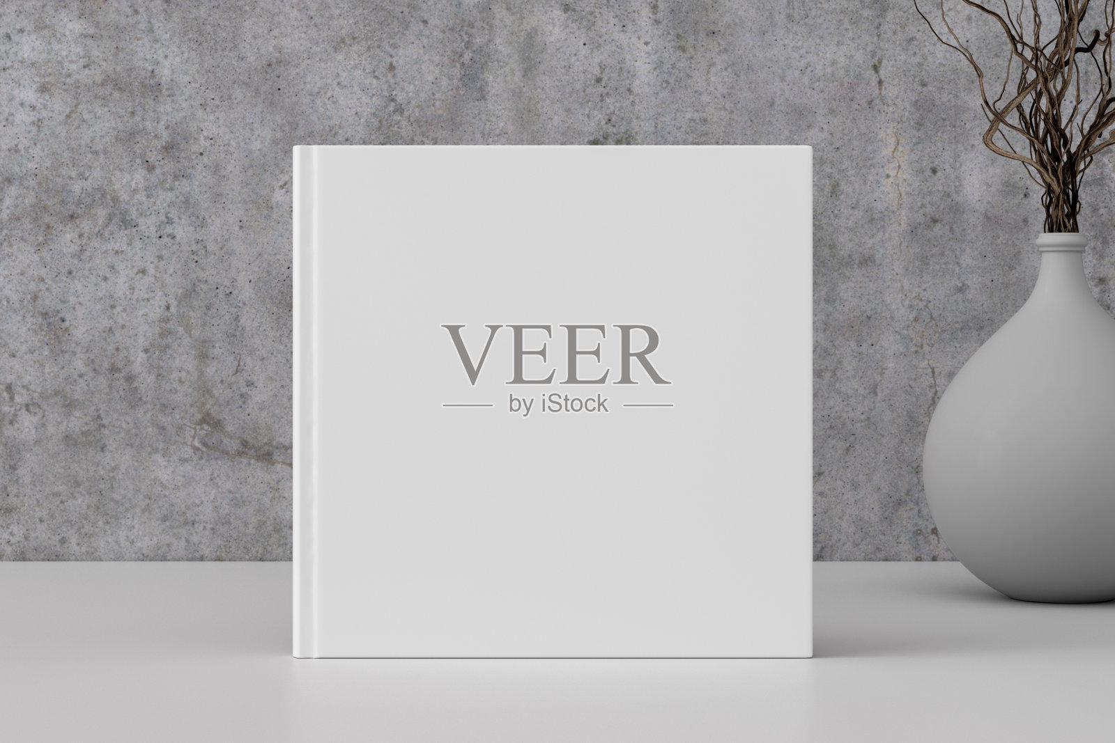 方形书封面模拟站在白色的桌子与混凝土墙背景。照片摄影图片