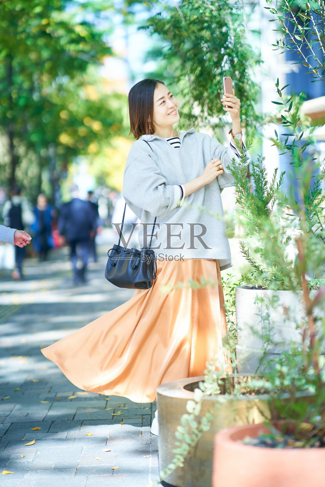 年轻女子举起智能手机照片摄影图片