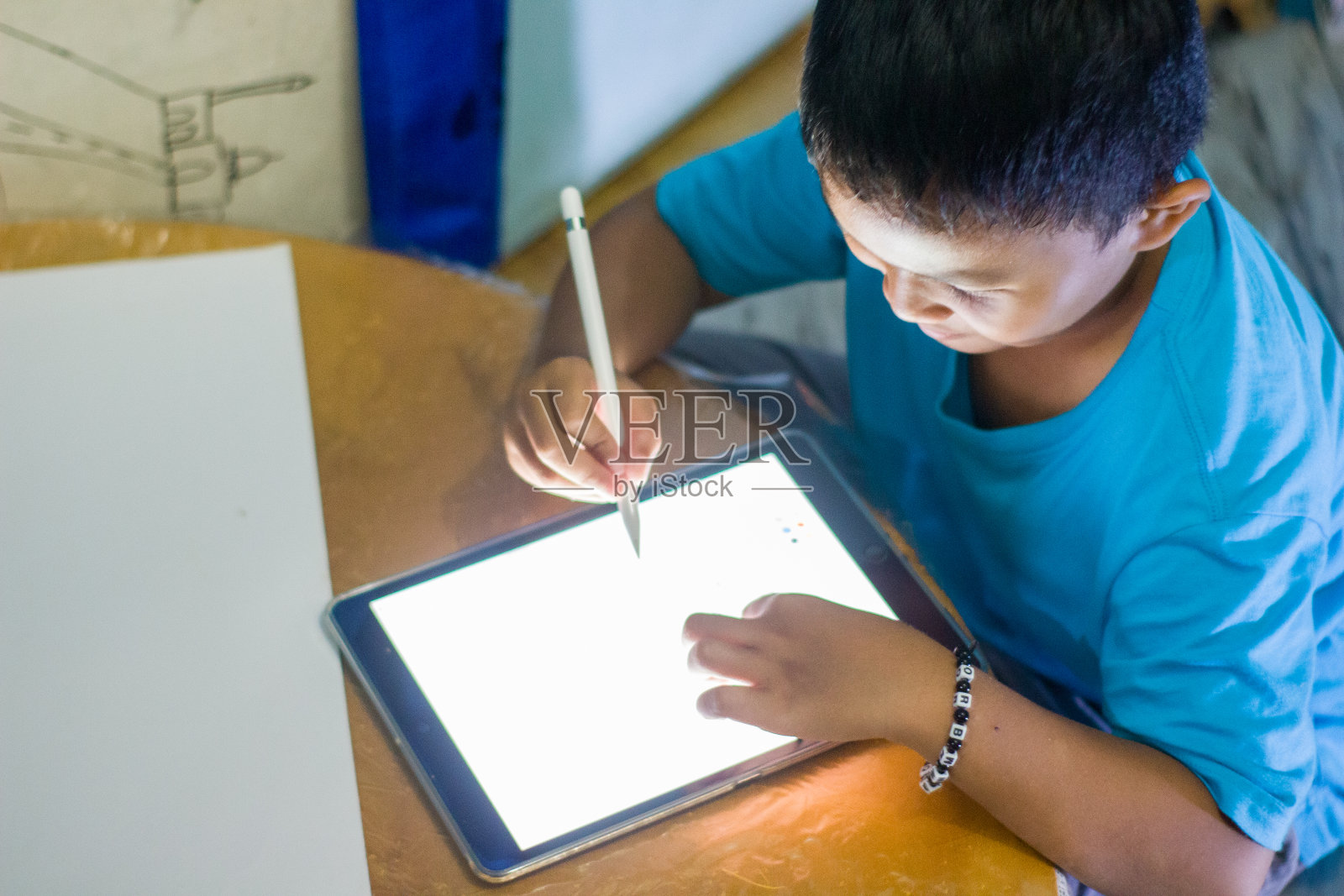 男孩用平板手机做作业照片摄影图片