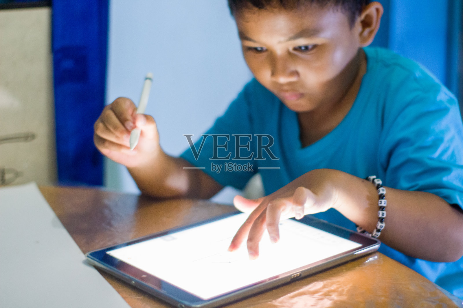 男孩用平板手机做作业照片摄影图片