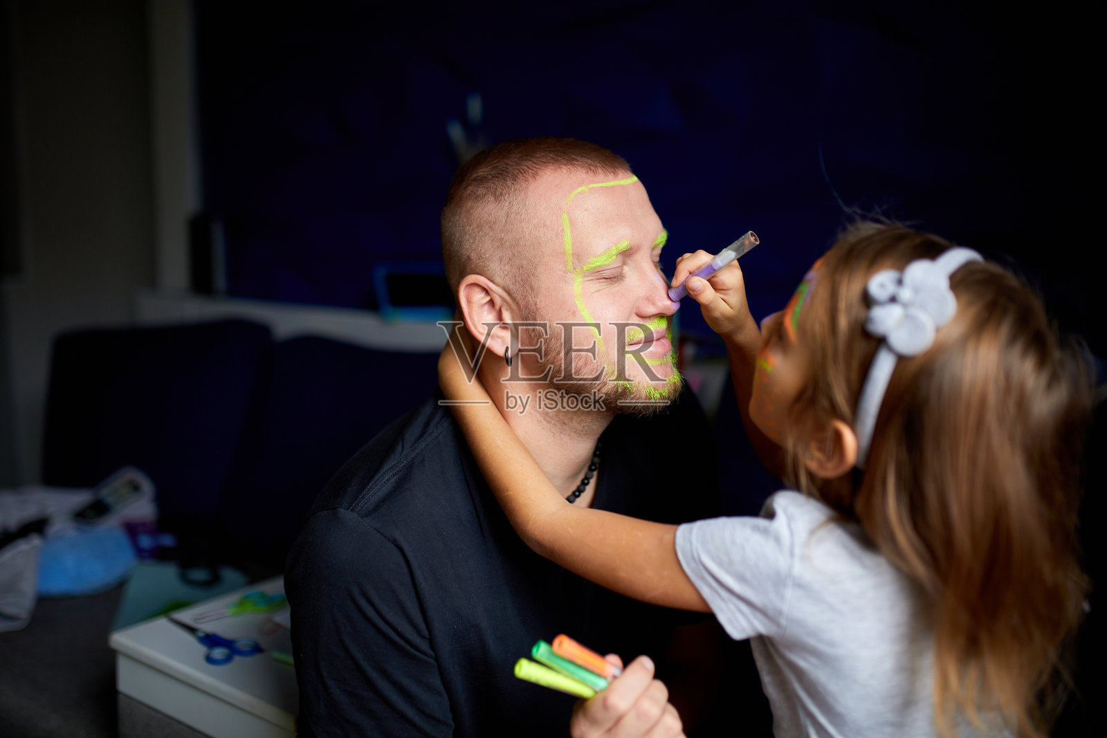 女儿和父亲画了一张脸，一起在家里玩，休闲照片摄影图片