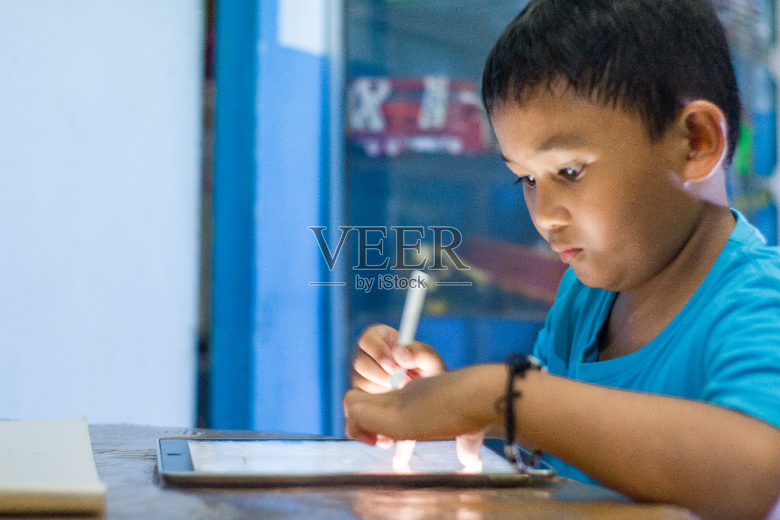 男孩用平板手机做作业照片摄影图片