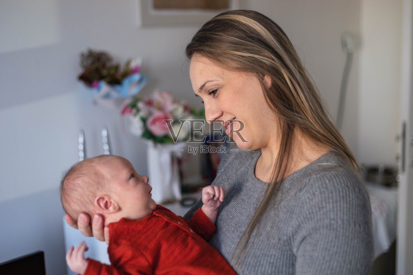 一个刚出生的婴儿和他的妈妈相视而笑。照片摄影图片