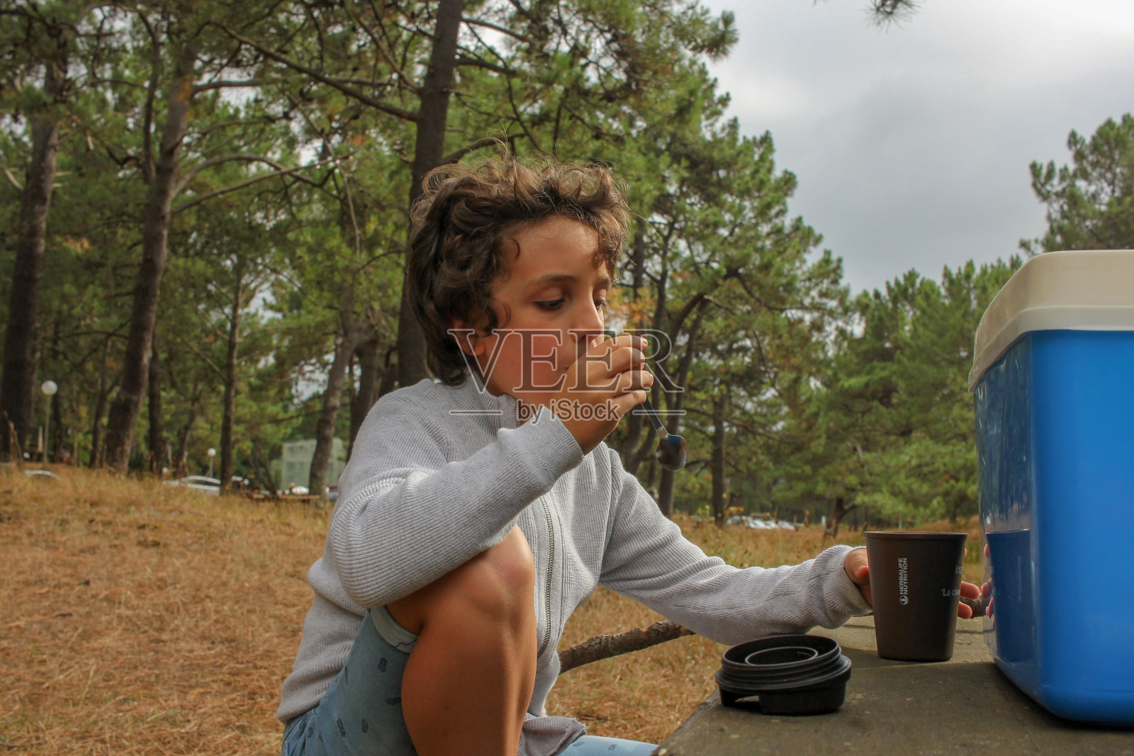 假期结束时，男孩在森林里吃零食照片摄影图片