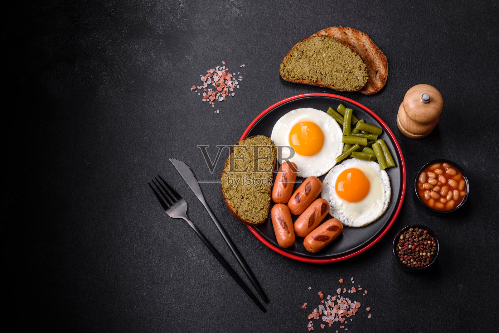 美味的英式早餐，有煎蛋、豆子、芦笋、香肠和香料和香草照片摄影图片