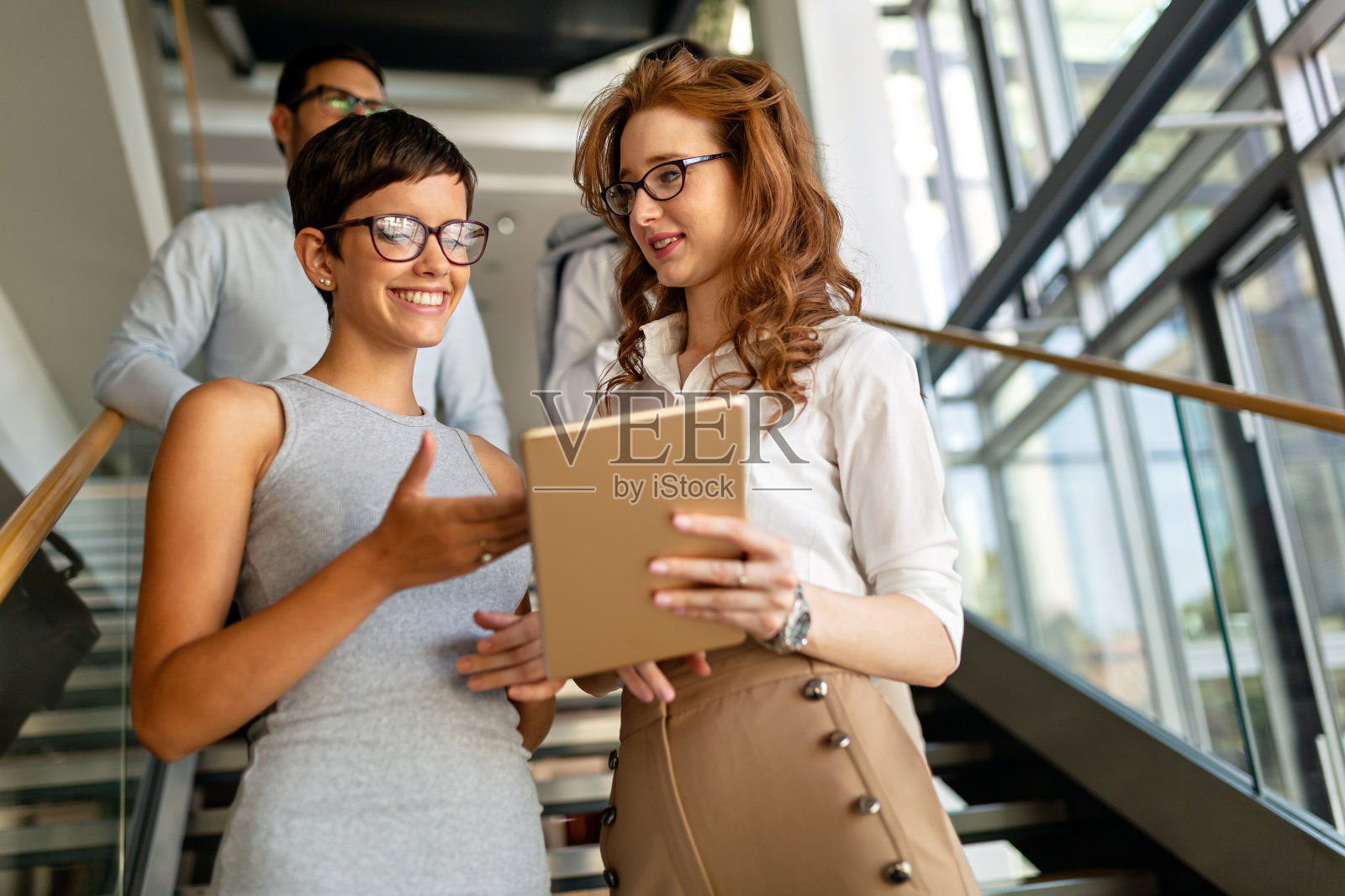 两位快乐成功的商业女性的肖像，在办公室举行非正式会议照片摄影图片