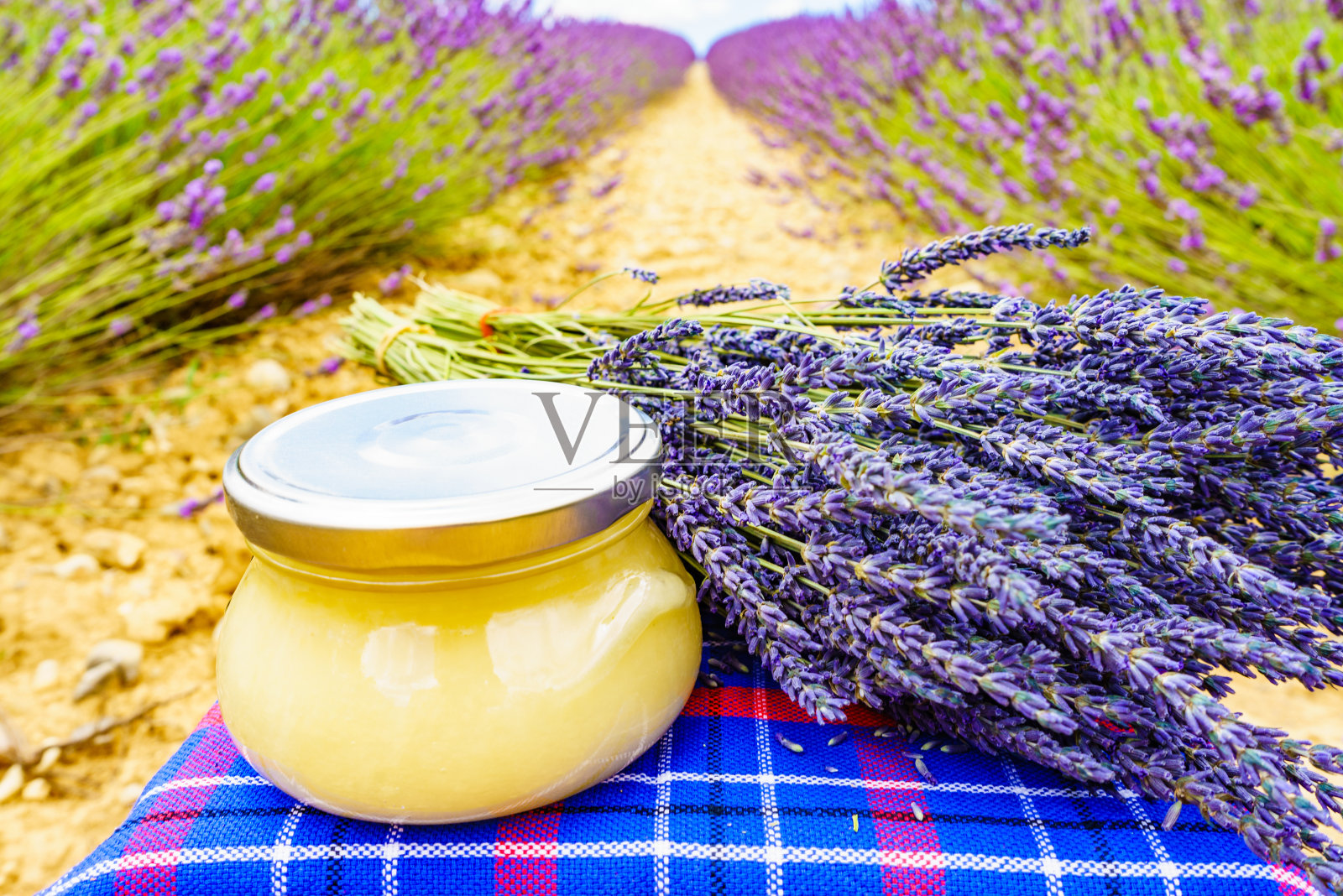 装有蜂蜜和薰衣草花的罐子。照片摄影图片