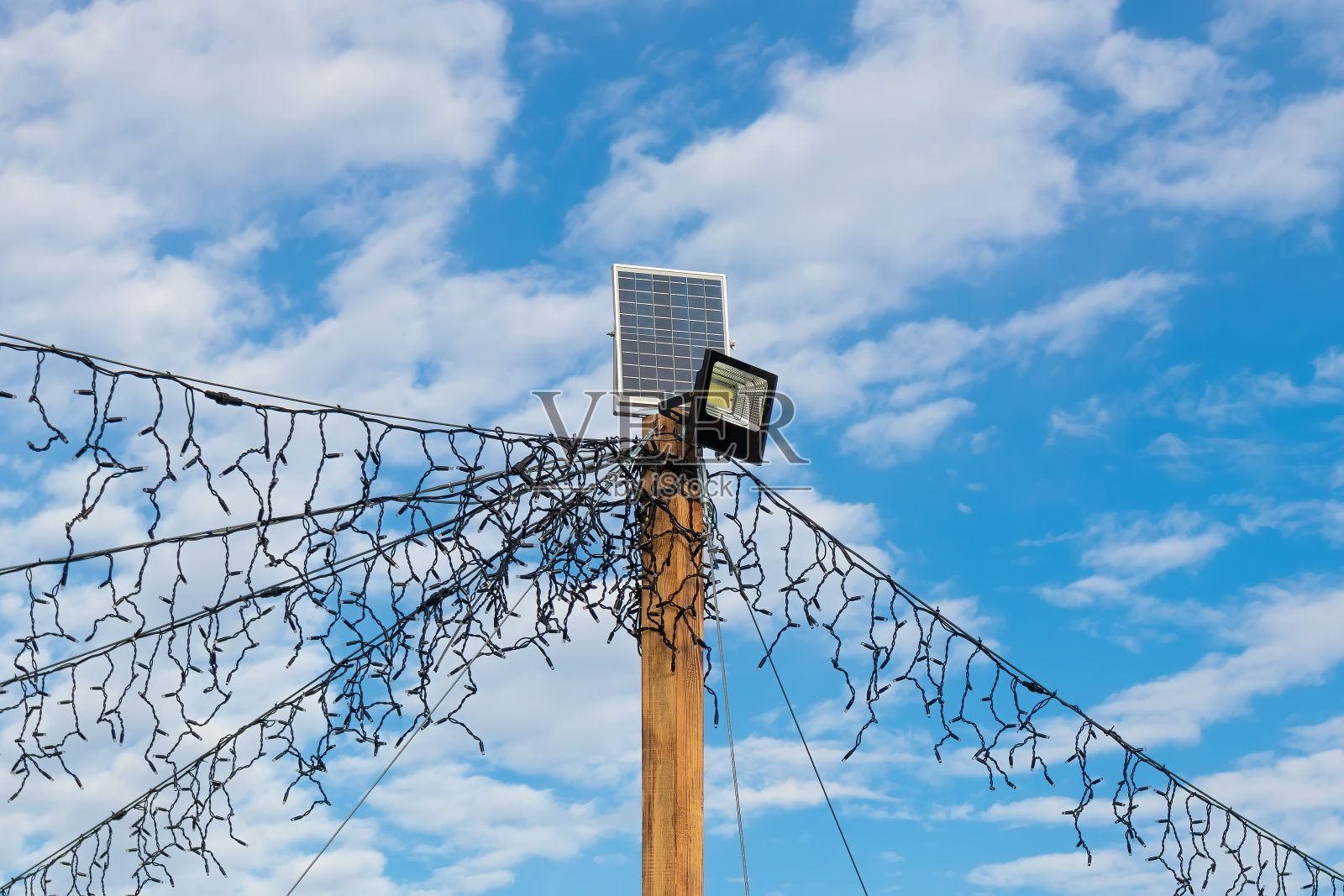 太阳能电池板，灯笼和LED花环在木杆上照片摄影图片