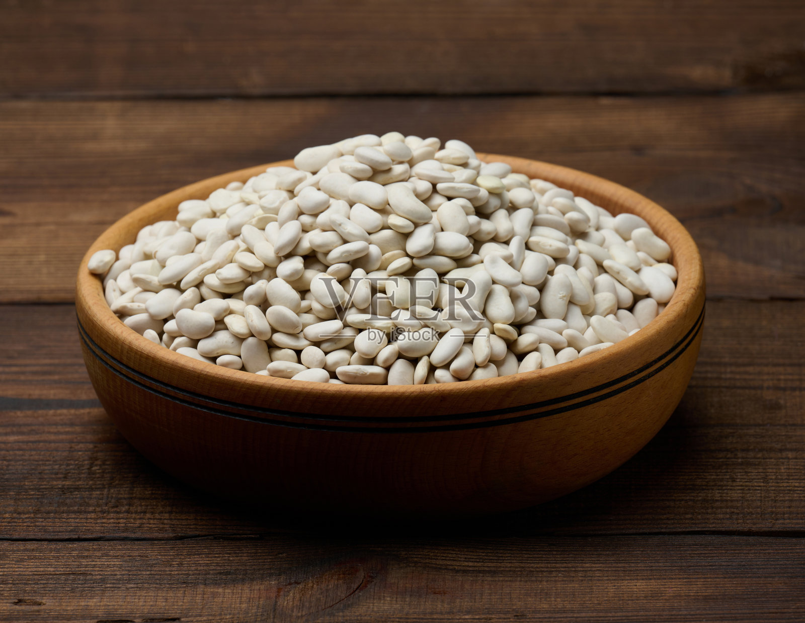 白色的生豆子放在木制的盘子里，背景是木制的照片摄影图片