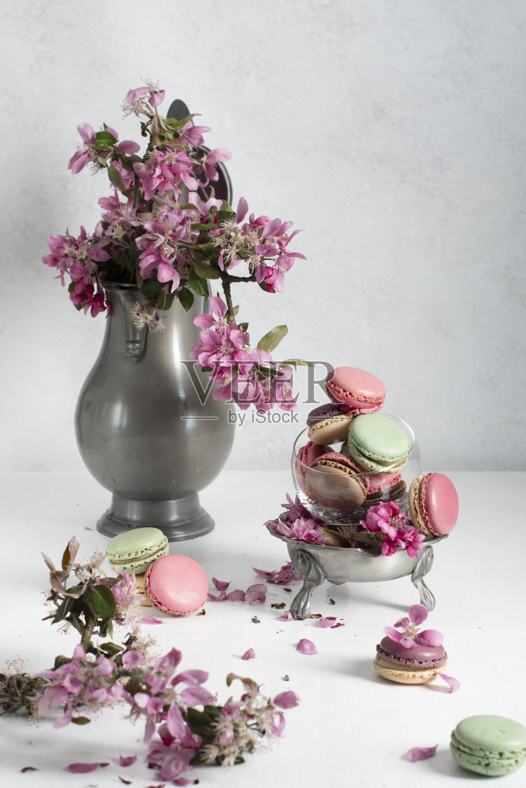 春天静物与彩色蛋白杏仁饼和粉红色的苹果树花在一个锡照片摄影图片