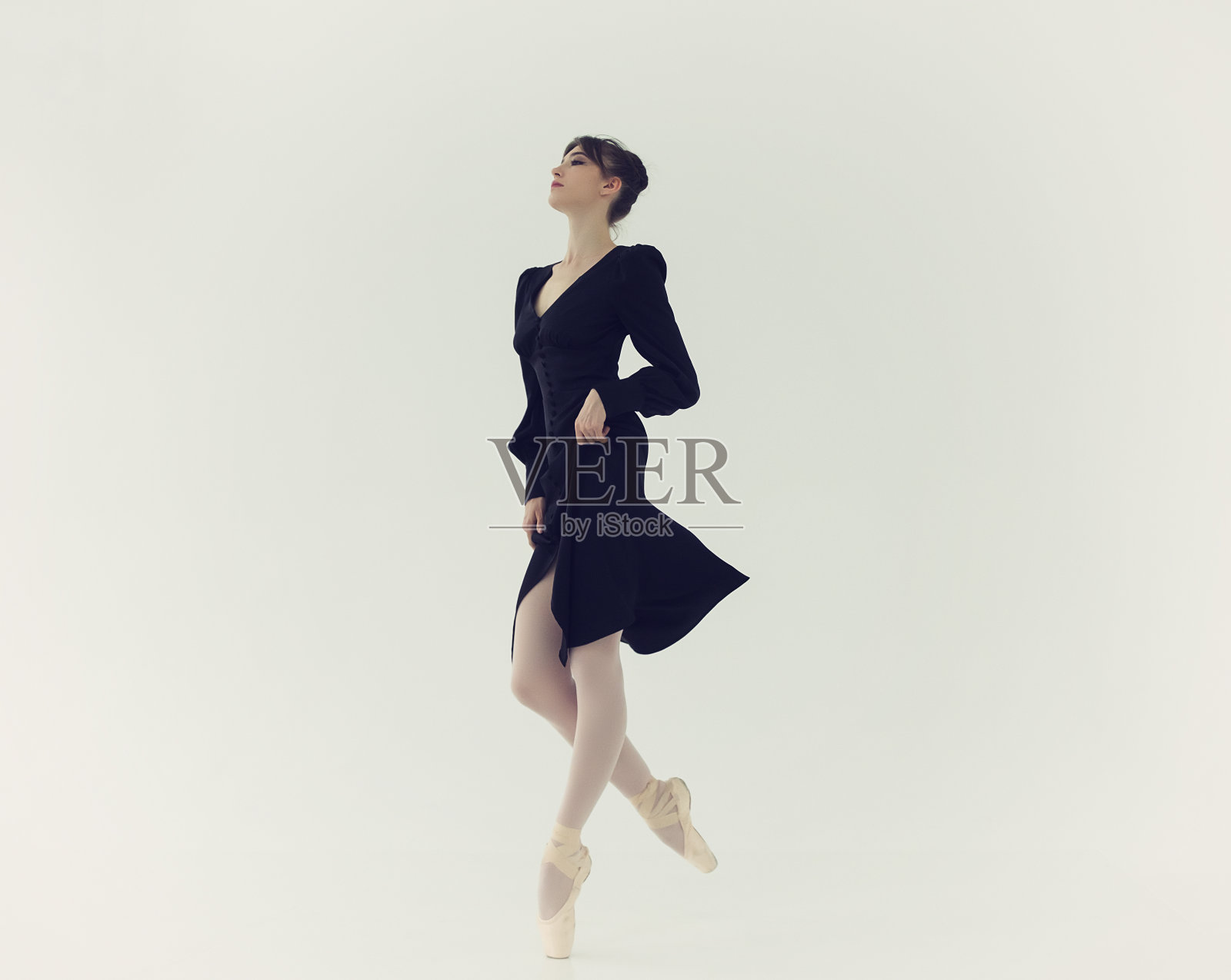 穿着黑色连衣裙的芭蕾舞女演员在手指上性感地移动照片摄影图片