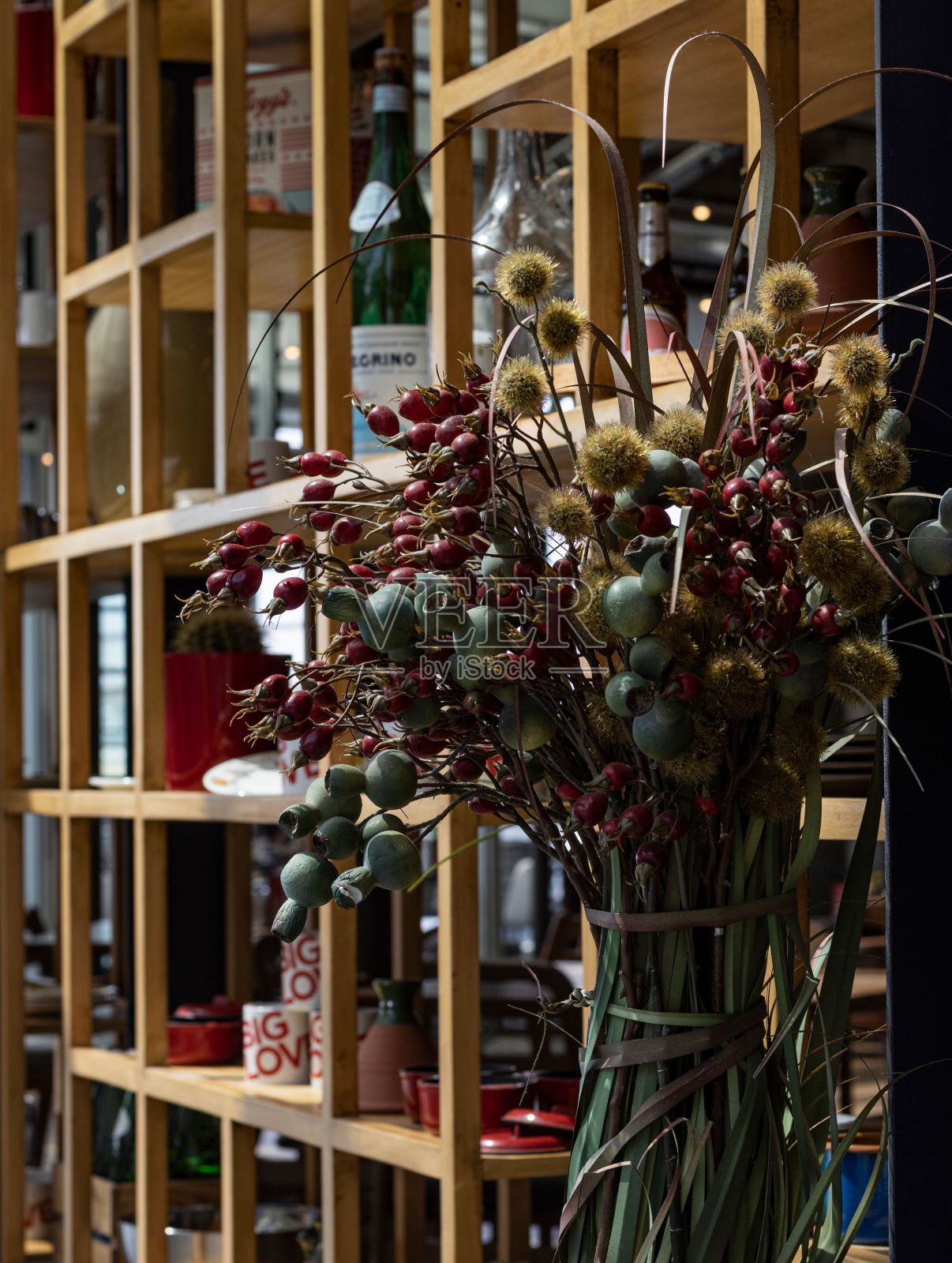 垂直拍摄的花瓶与干燥的深色花朵靠近一个柜子照片摄影图片