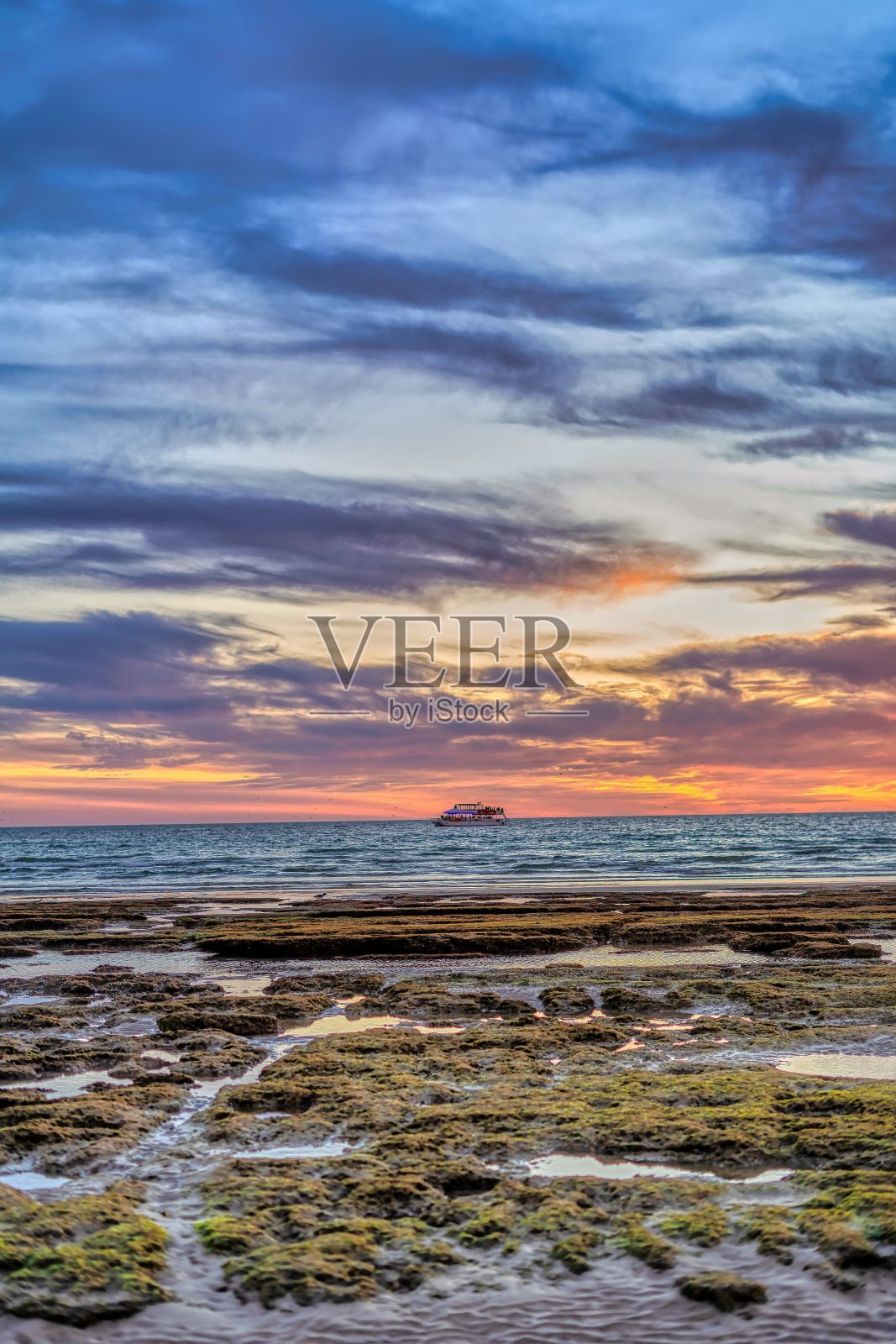 在美丽的日落天空下的海滩垂直拍摄照片摄影图片