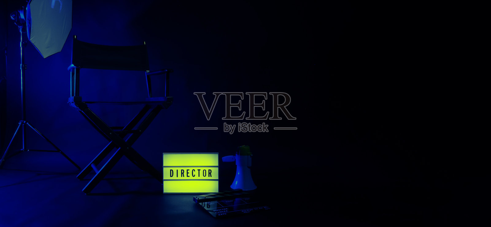导演椅与影院灯箱标志导演文字和隔板扩音器和黑色背景工作室。电影工业中使用的视频制作或拍摄设备上的导演座。没有3D照片摄影图片