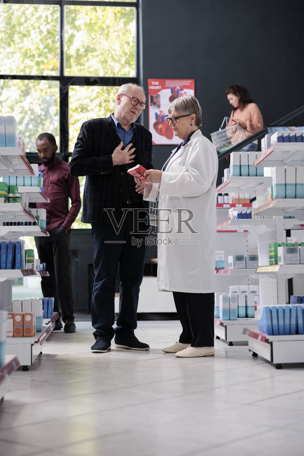 老年顾客在药房向药店职员询问药物治疗意见照片摄影图片