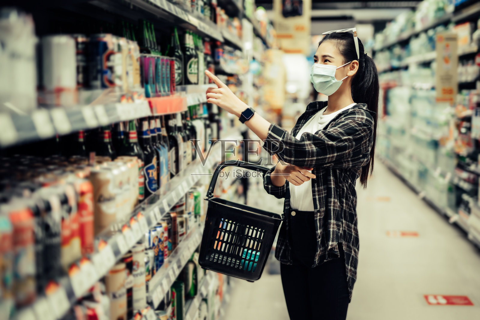 年轻女子戴着防护口罩在超市购物照片摄影图片