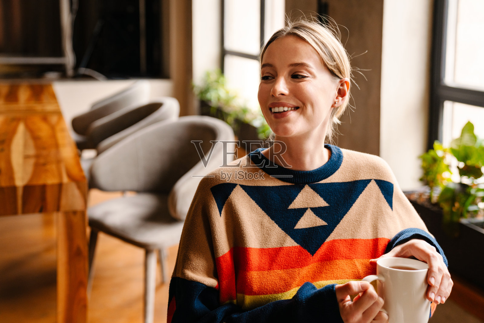 微笑的年轻女子坐在咖啡馆喝茶照片摄影图片