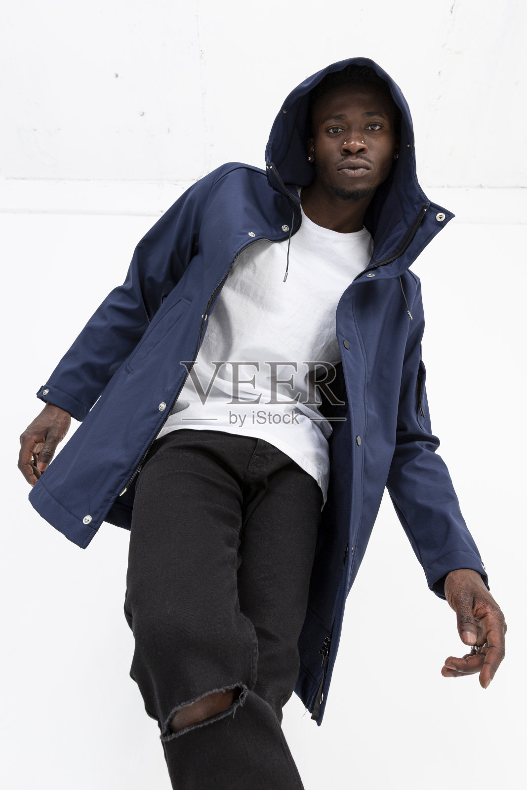 一名黑人男模特穿着牛仔夹克，前面是白色背景。照片摄影图片