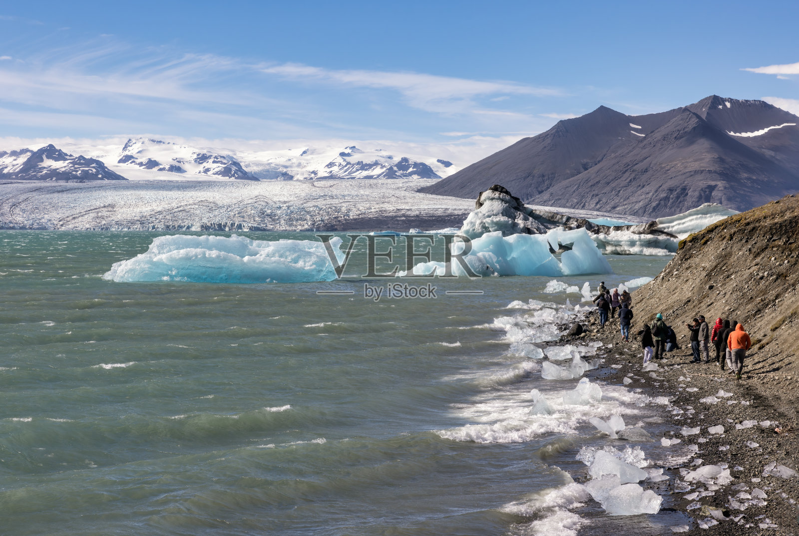 冰岛Jokulsarlon冰川泻湖，游客在湖中欣赏冰山照片摄影图片