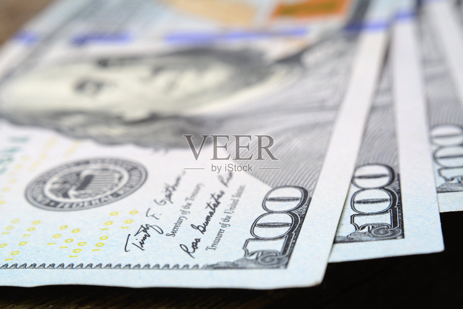 一张100美元的木桌特写照片摄影图片