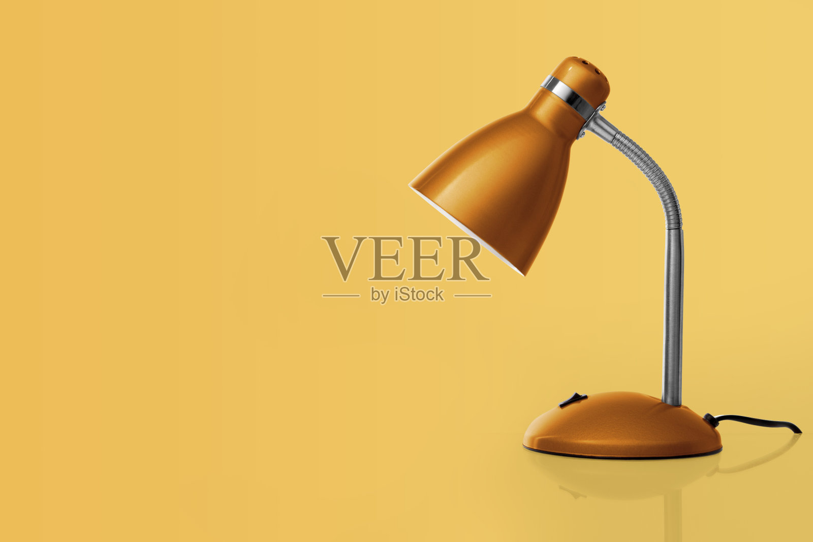 橙色的台灯，浅橙色的背景照片摄影图片