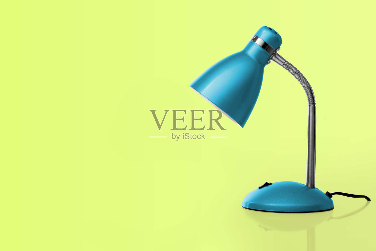 黄绿背景下的蓝色台灯照片摄影图片