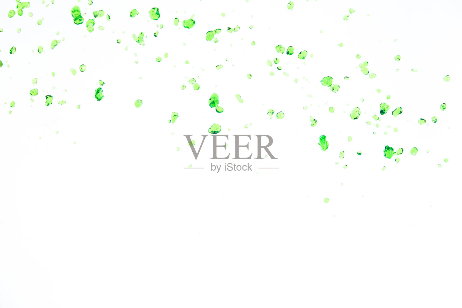 许多来自大自然的绿色汁滴在空气中飞溅。水绿叶从天而降，净化干净自然。许多形状的水飞溅形式流过白色背景孤立照片摄影图片