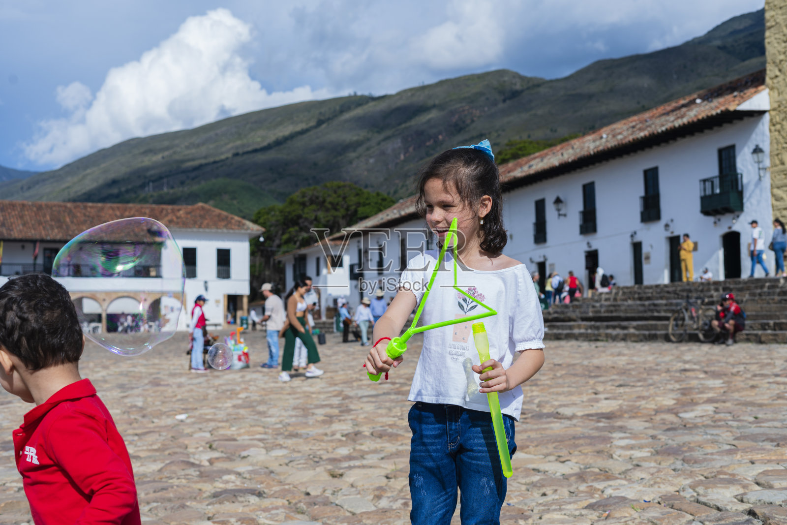 在博亚卡省莱瓦镇历史广场玩泡泡的拉丁裔兄弟照片摄影图片