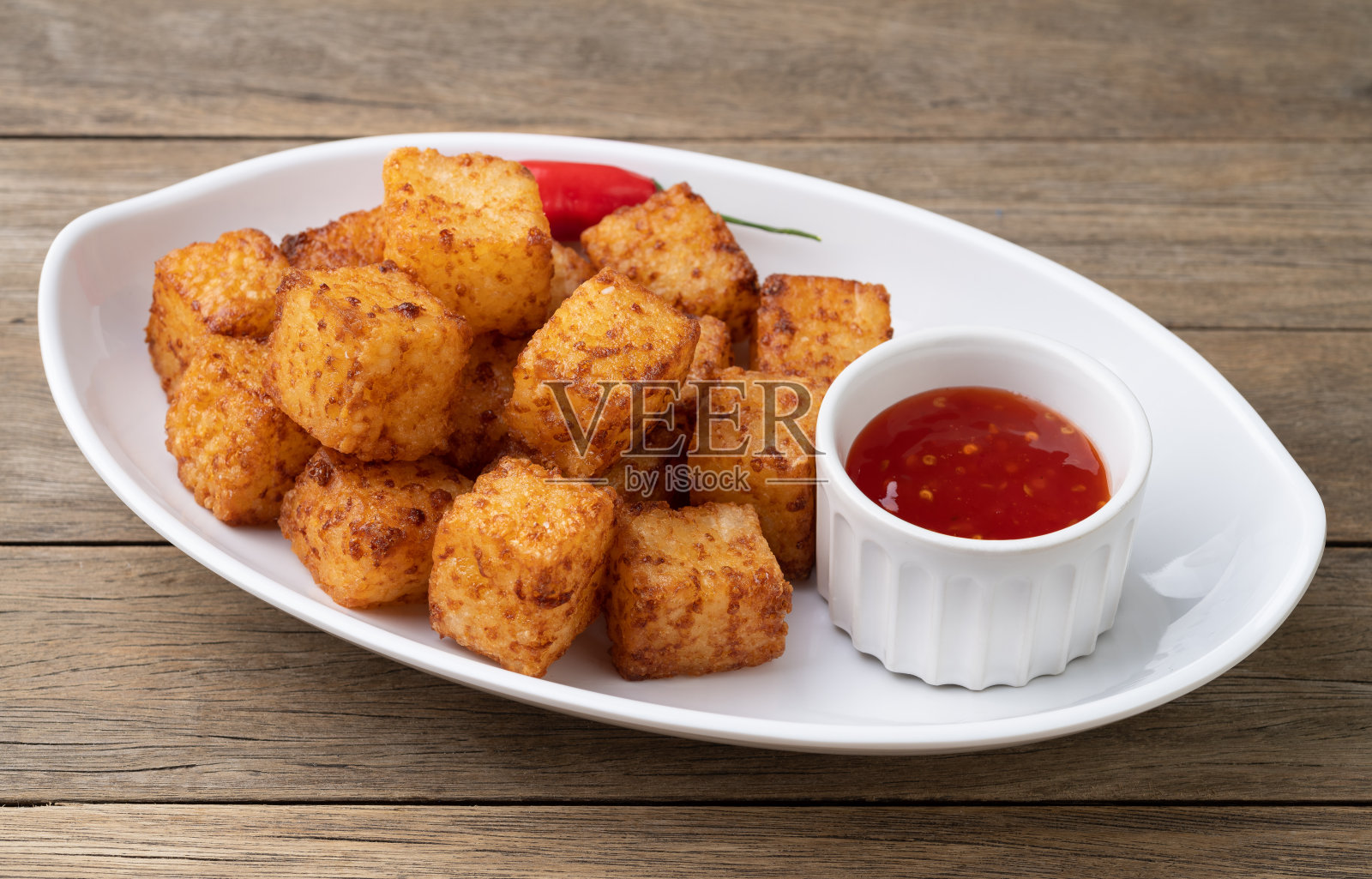 木薯丁，典型的巴西东北部食物，辣椒糖浆放在木桌上照片摄影图片