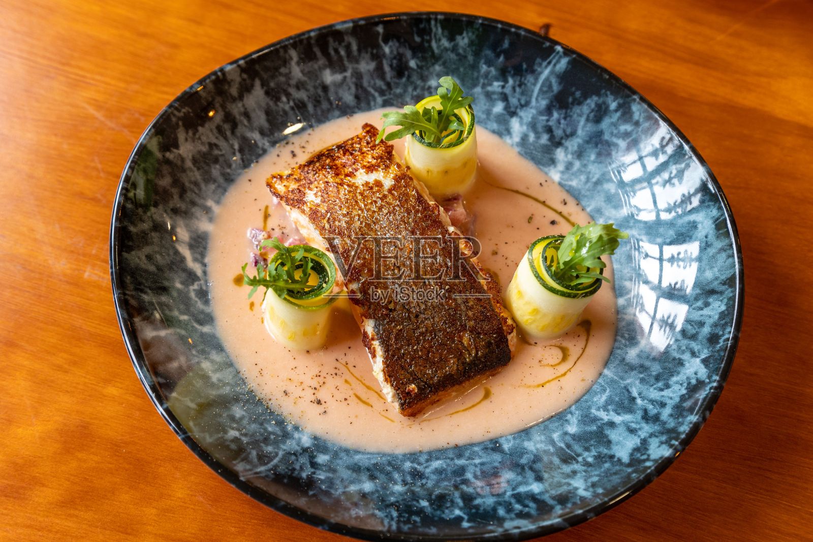 用黄瓜卷装饰的烤鱼特写照片摄影图片