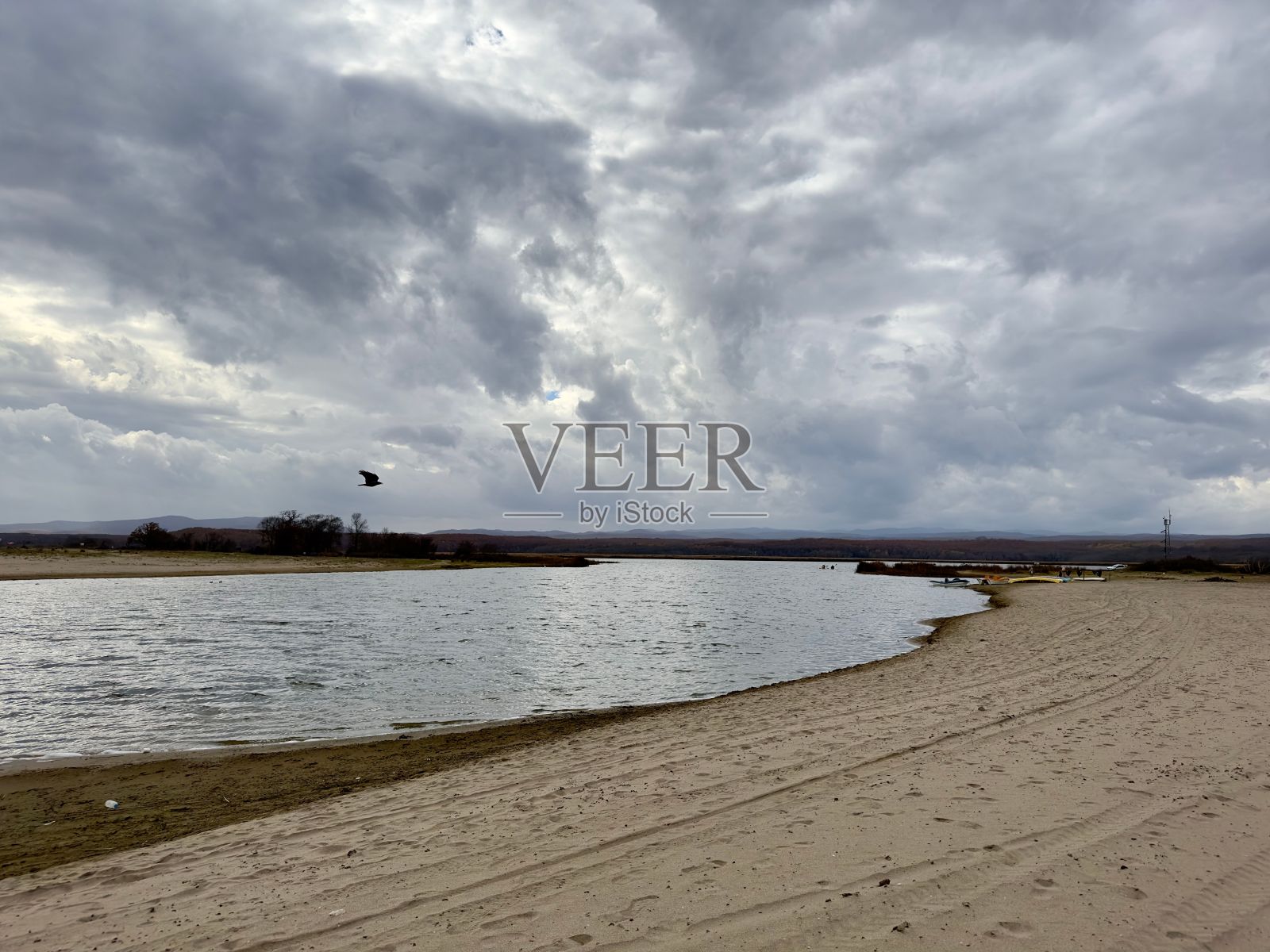 岸边清澈的海水和浑浊的天空为背景照片摄影图片