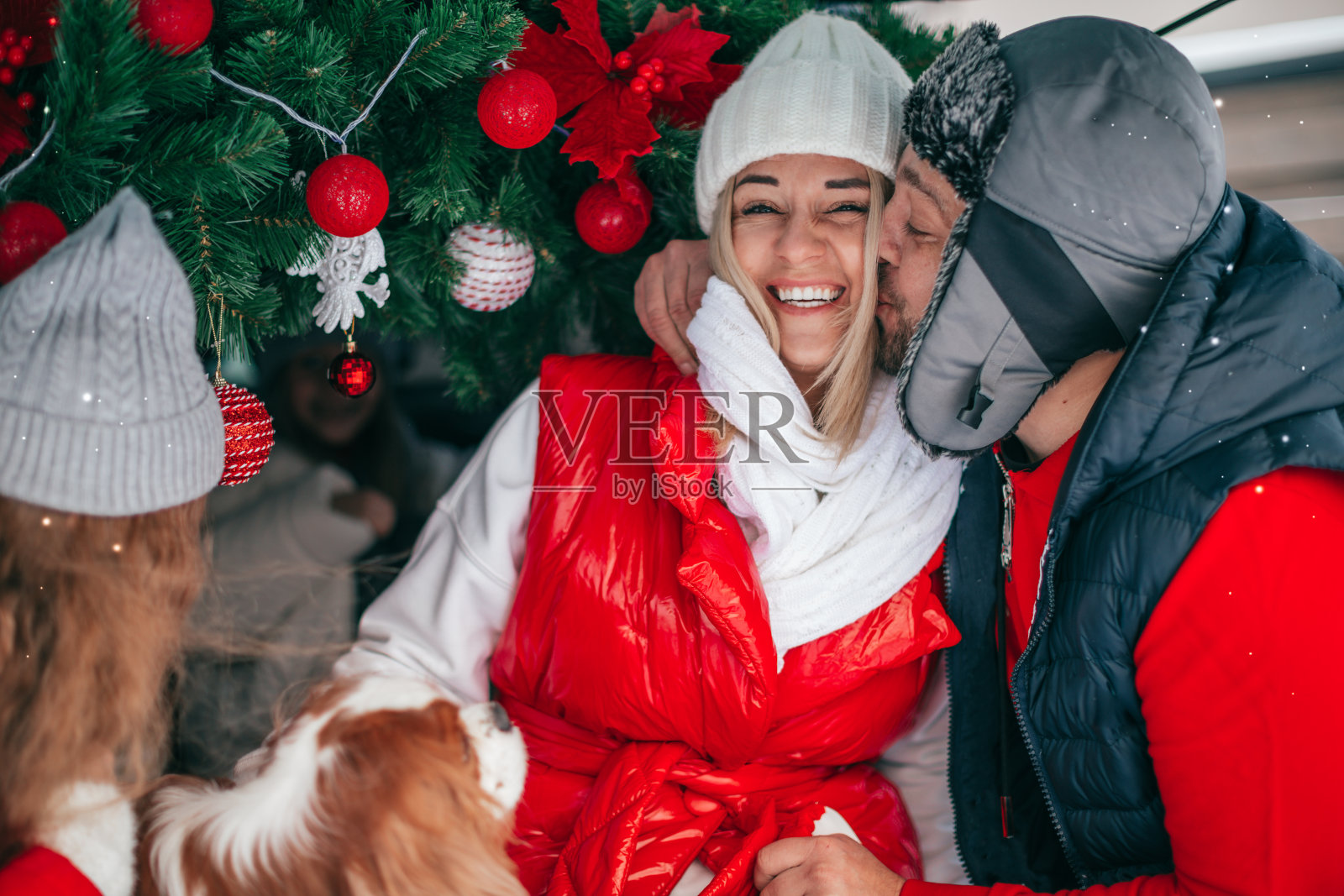 正面特写肖像，幸福的夫妇在温暖的冬季衣服摆姿势在外面红色的圣诞装饰照片摄影图片