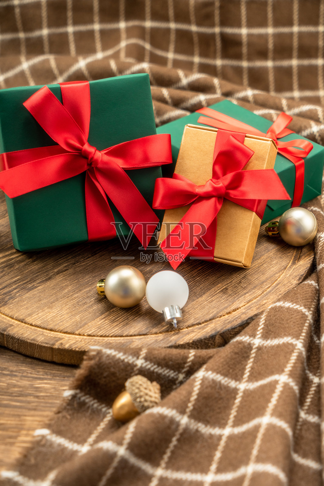 圣诞礼物在木制砧板与圣诞装饰。照片摄影图片