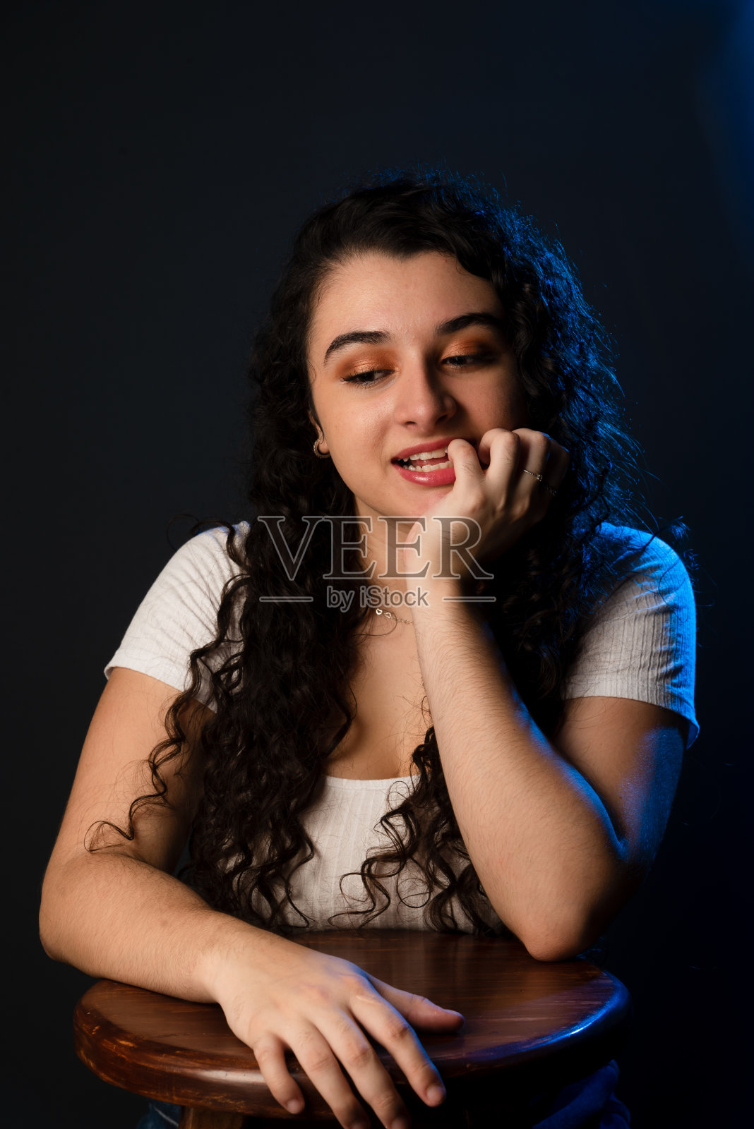 快乐的年轻美丽的女人，一只手放在她的嘴上。照片摄影图片