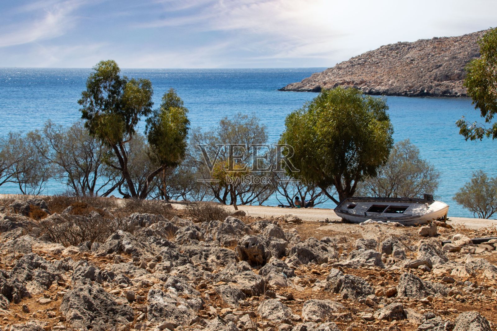 在农村地区，海边附近的废弃船只，背景是蓝色的海景照片摄影图片