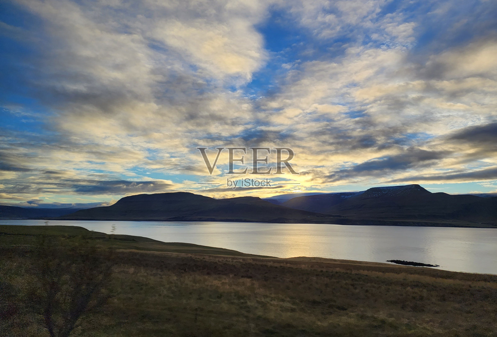 日落时分多云天空下的湖山美景照片摄影图片