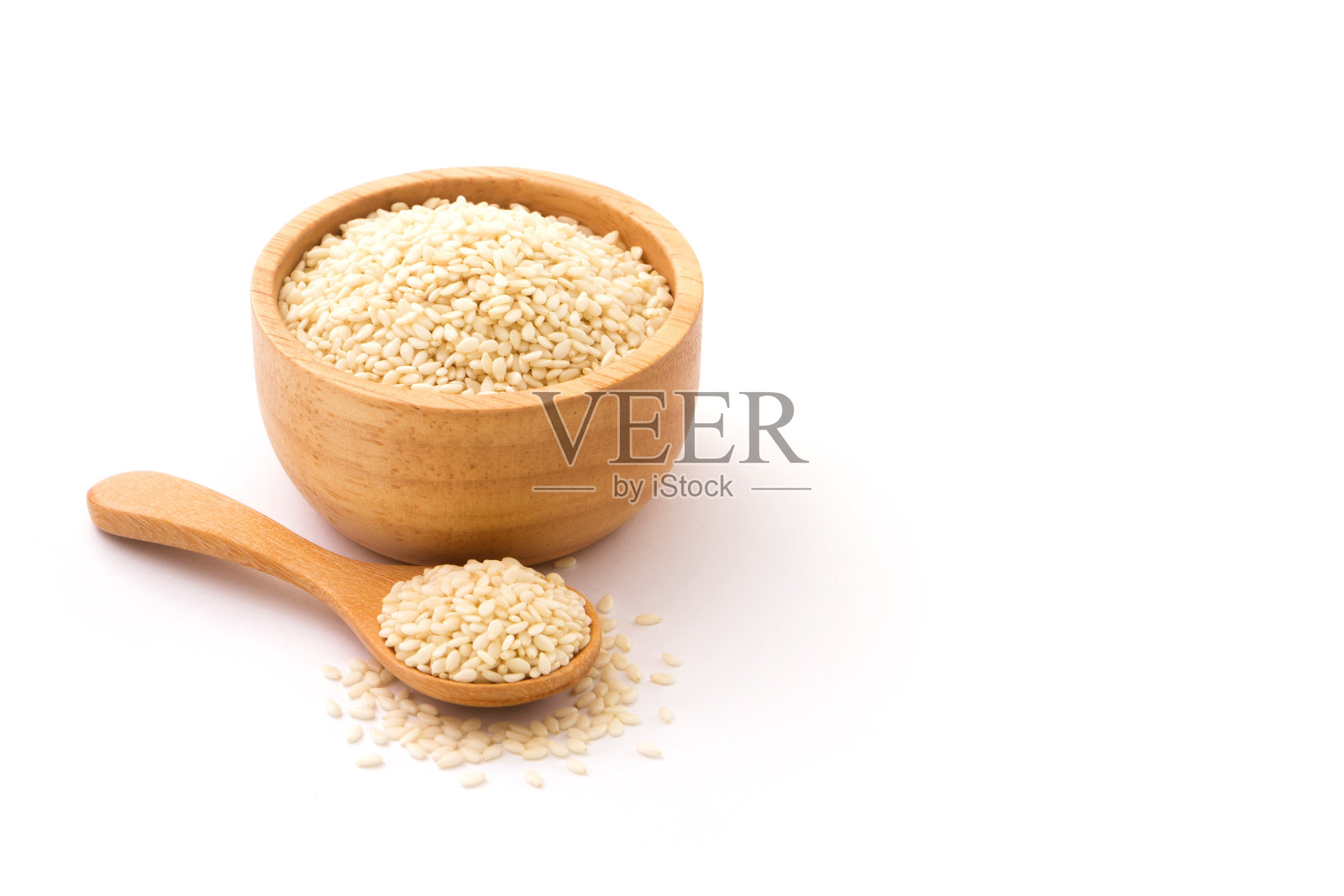 木碗和木勺里的白芝麻被隔离在白色背景上。照片摄影图片