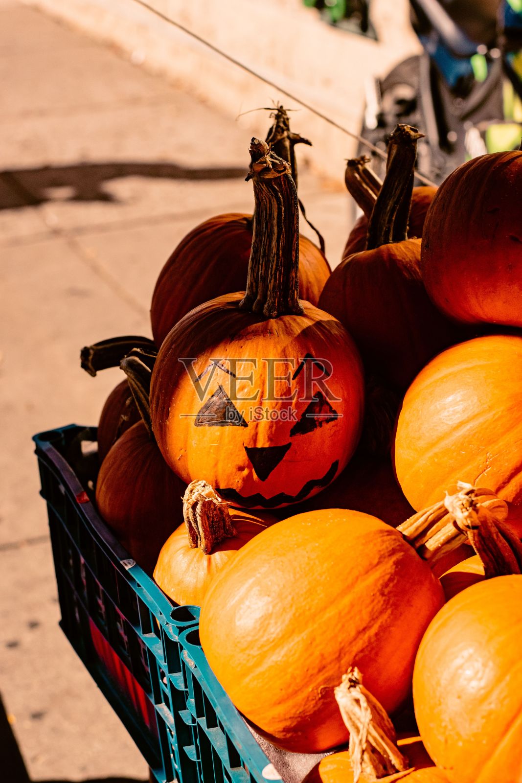 成堆的万圣节南瓜装饰在蓝色的车在街上照片摄影图片