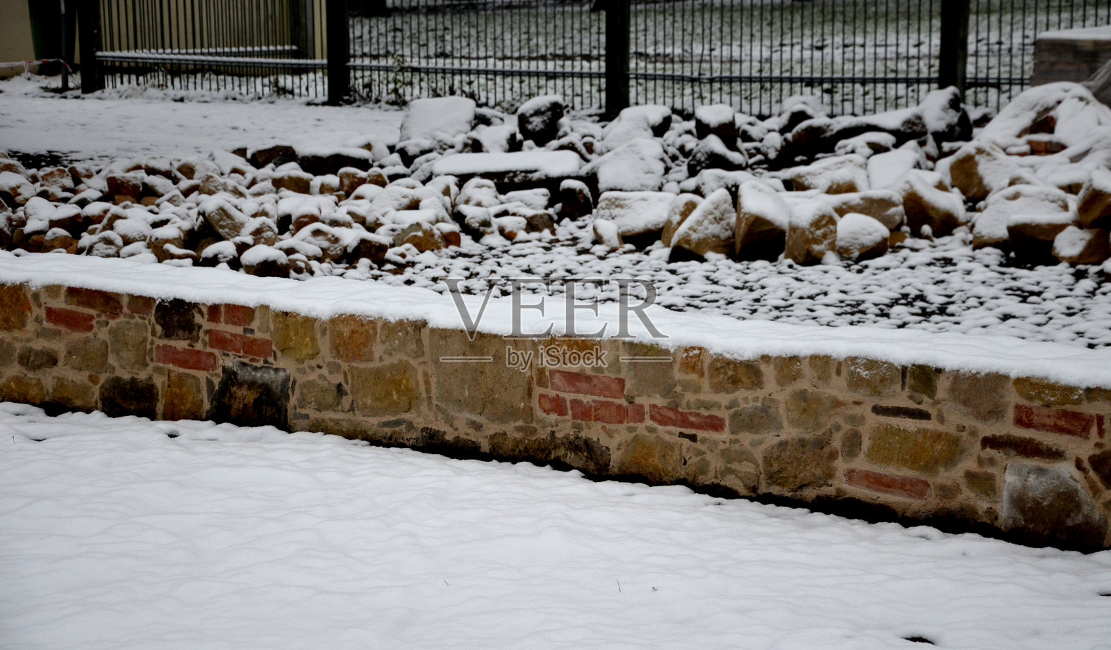 石质路面刚刚铺干，在两块钢板之间的砾石回填中。砂岩和烧焦的砖块带着乡村的感觉。狭窄的公园小径在草本花园，低，保留，烧焦照片摄影图片