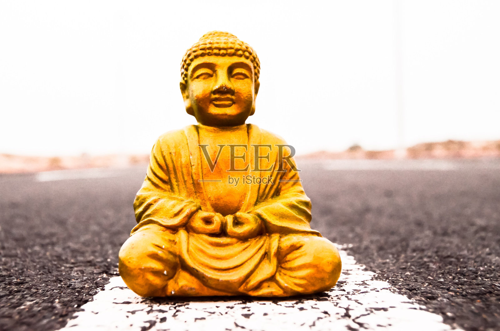 柏油路上的古佛像照片摄影图片