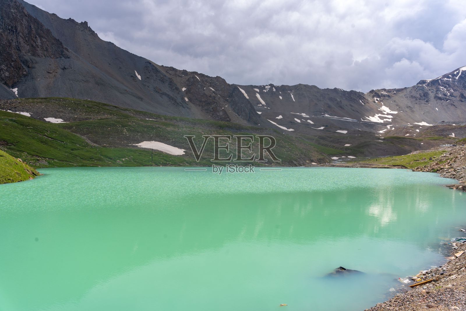 在阴天，一个被群山环绕的蓝色湖泊的美丽镜头照片摄影图片