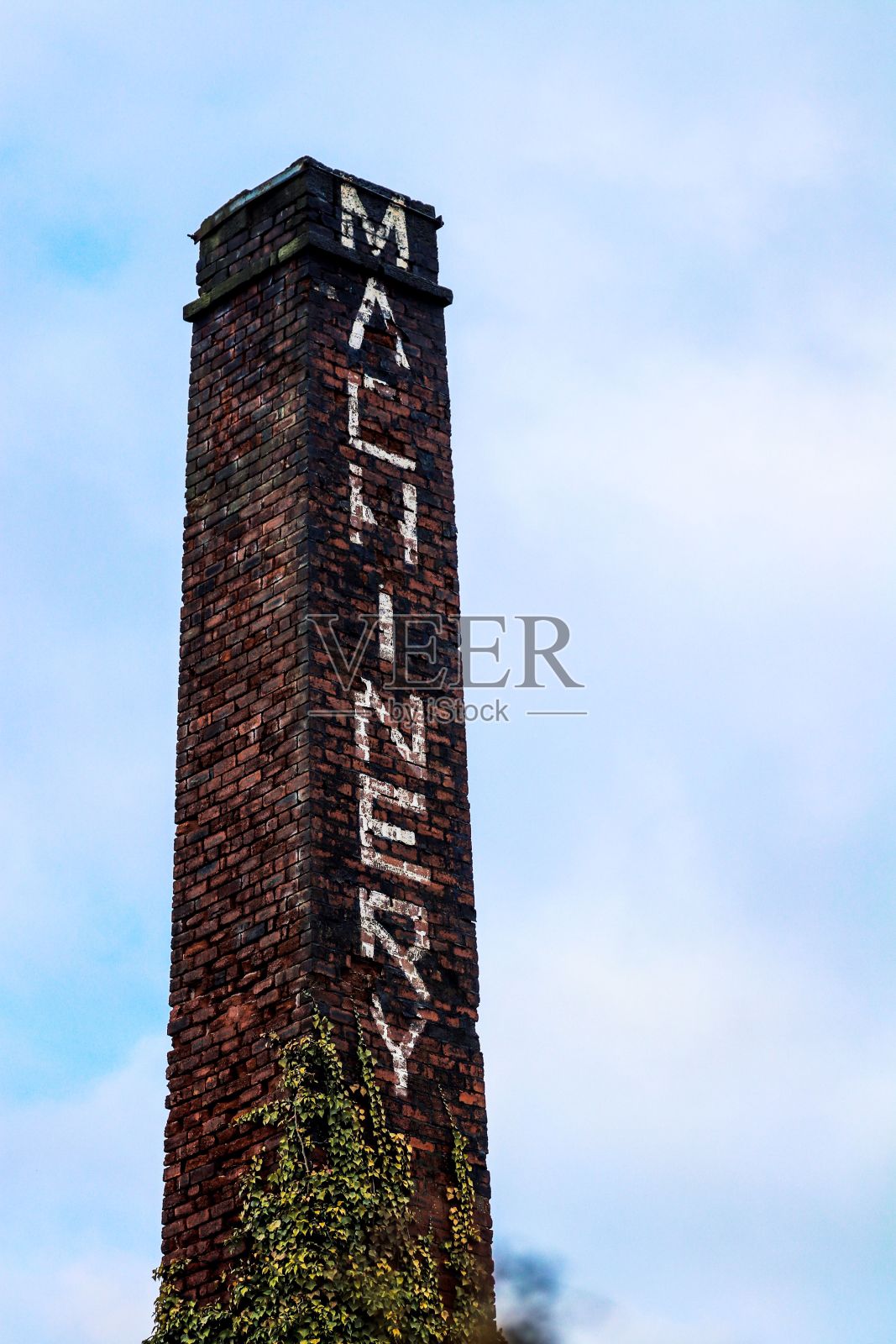 垂直拍摄的旧石塔与机械文字与蓝天照片摄影图片