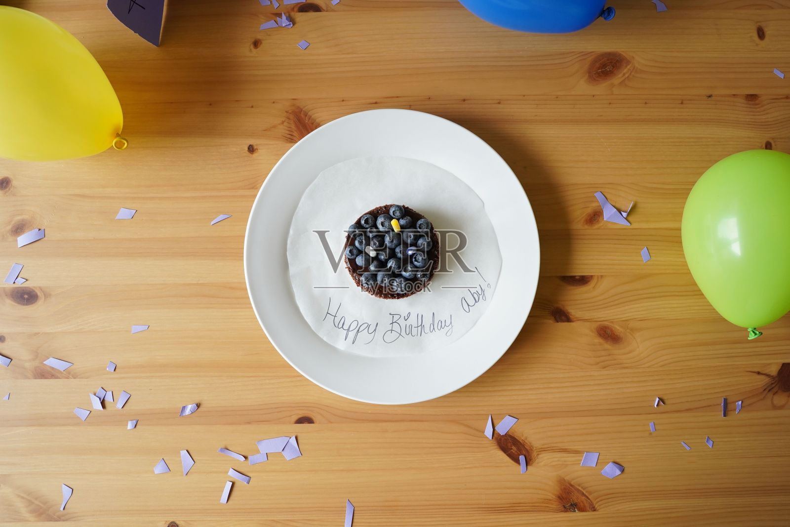 一张木桌上的蓝莓生日蛋糕和气球的俯视图照片摄影图片