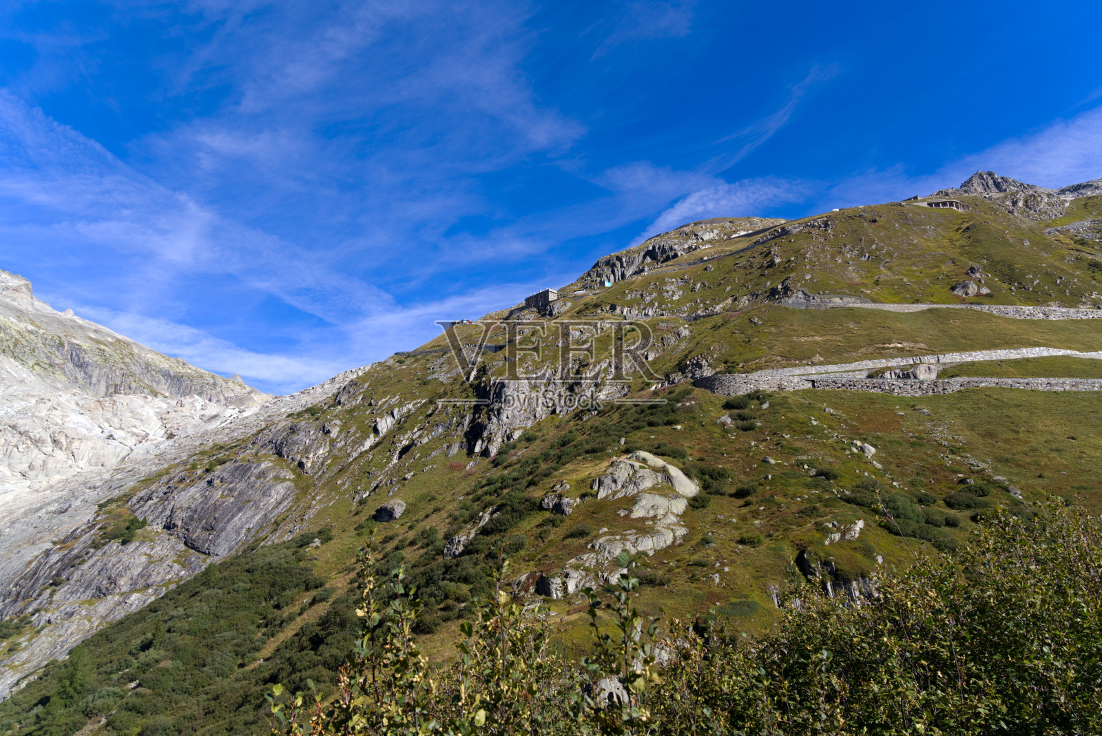 在一个阳光明媚的夏日，瑞士阿尔卑斯山脉Furkapass地区的蛇形公路的全景鸟瞰图。照片摄影图片