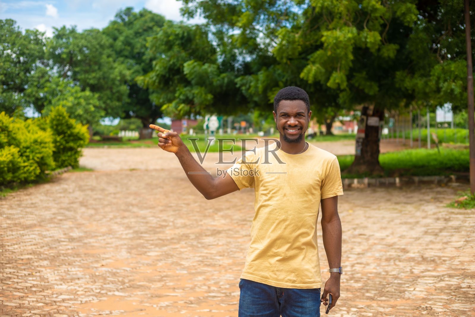 快乐的人站在公园里，指着一个方向照片摄影图片