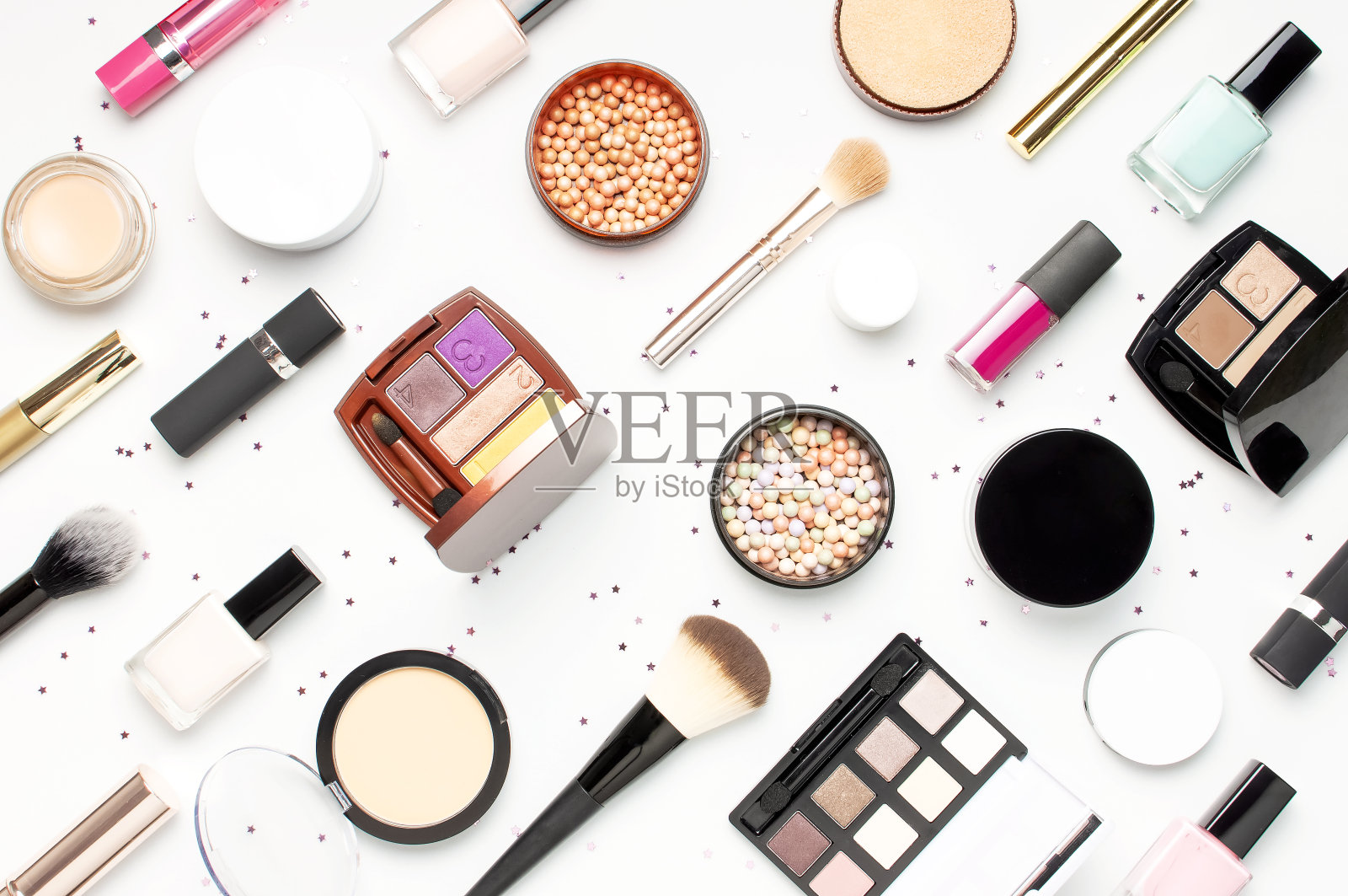 图案从一套装饰化妆品睫毛膏粉口红眼影腮红化妆刷，星星五彩纸屑在轻背景顶部视图平铺。美妆博主概念。时尚背景。化妆照片摄影图片