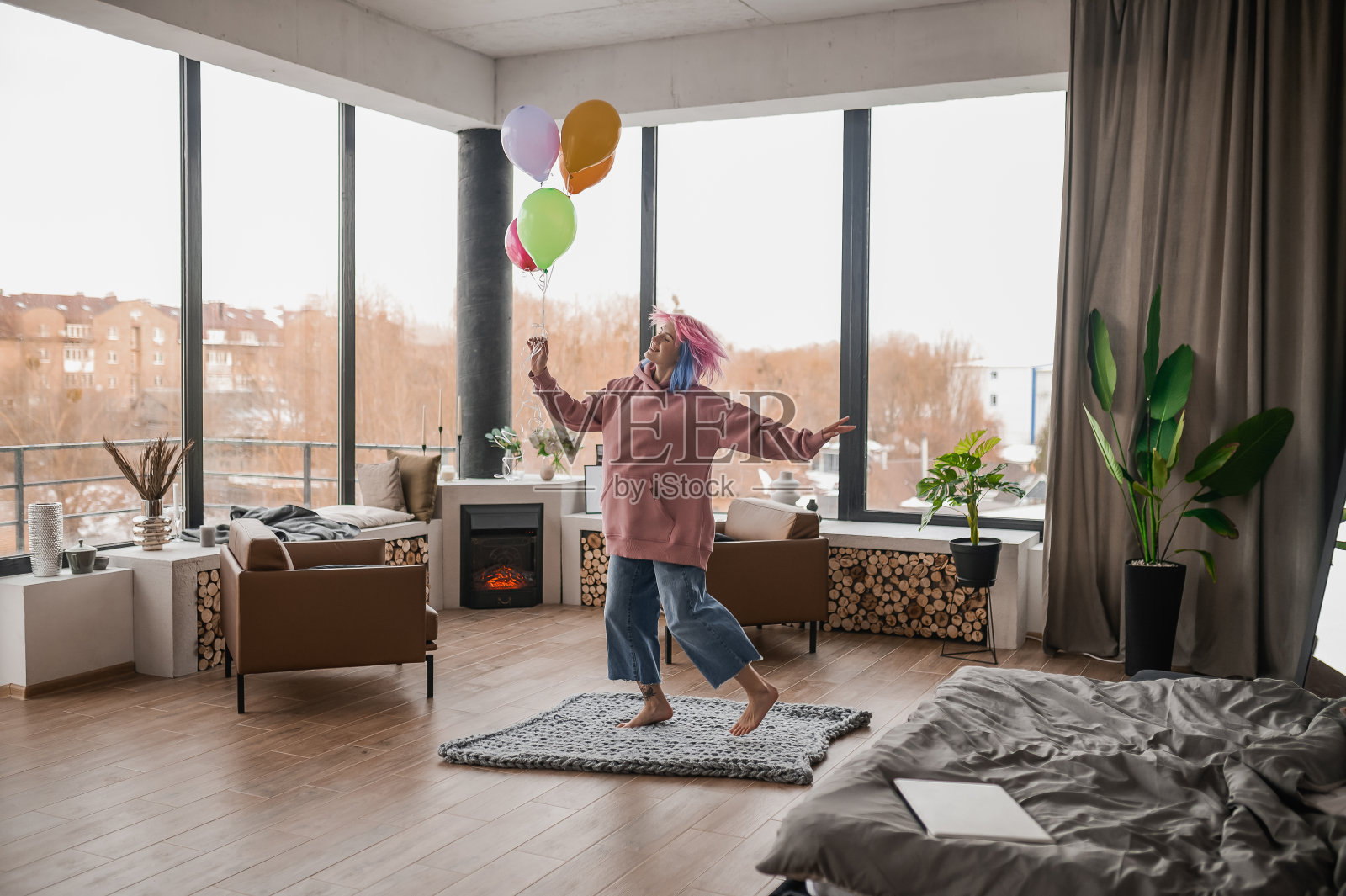 一个快乐的女孩抱着一堆彩色气球跳舞照片摄影图片