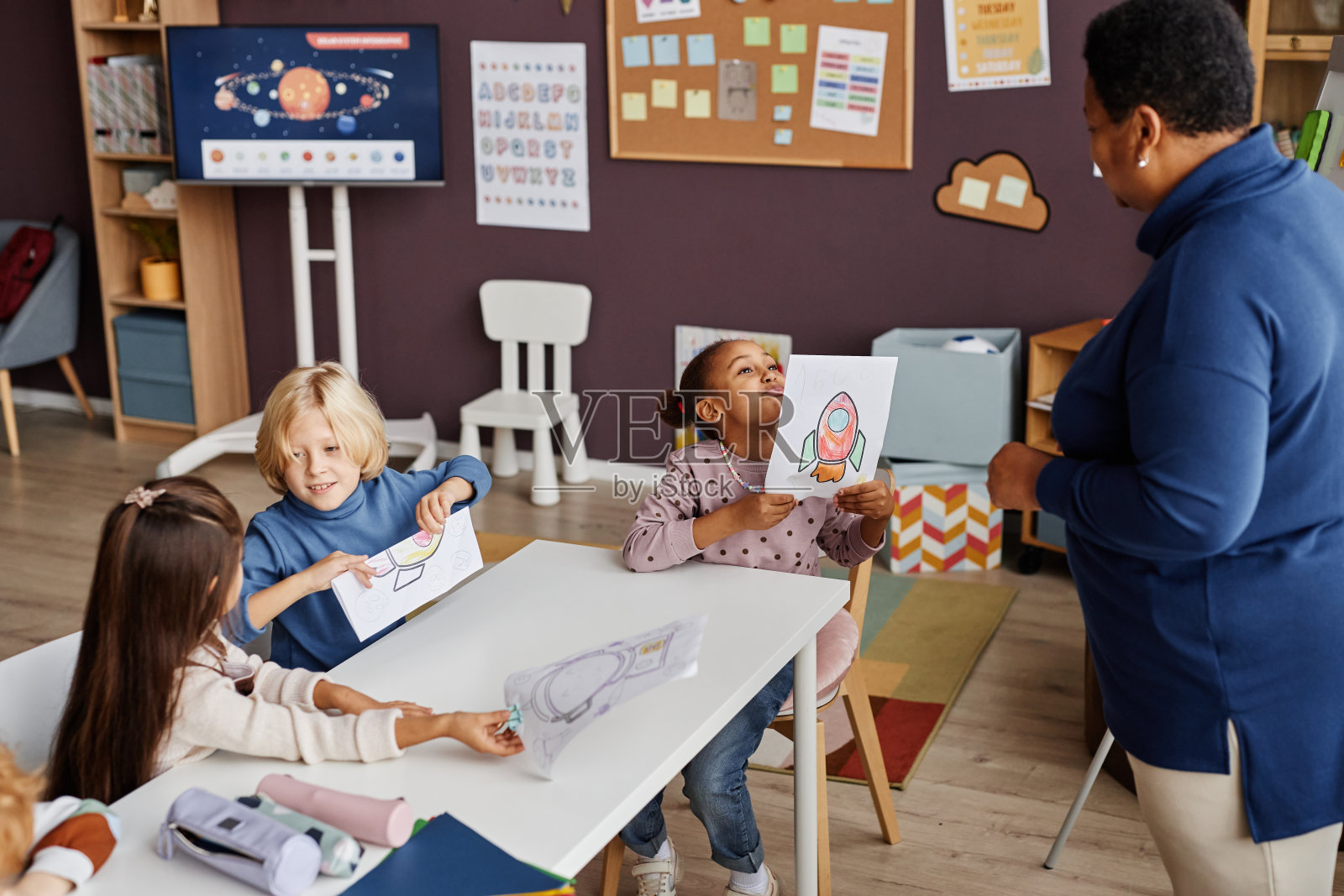 可爱的小学小学习者吹嘘她的画照片摄影图片