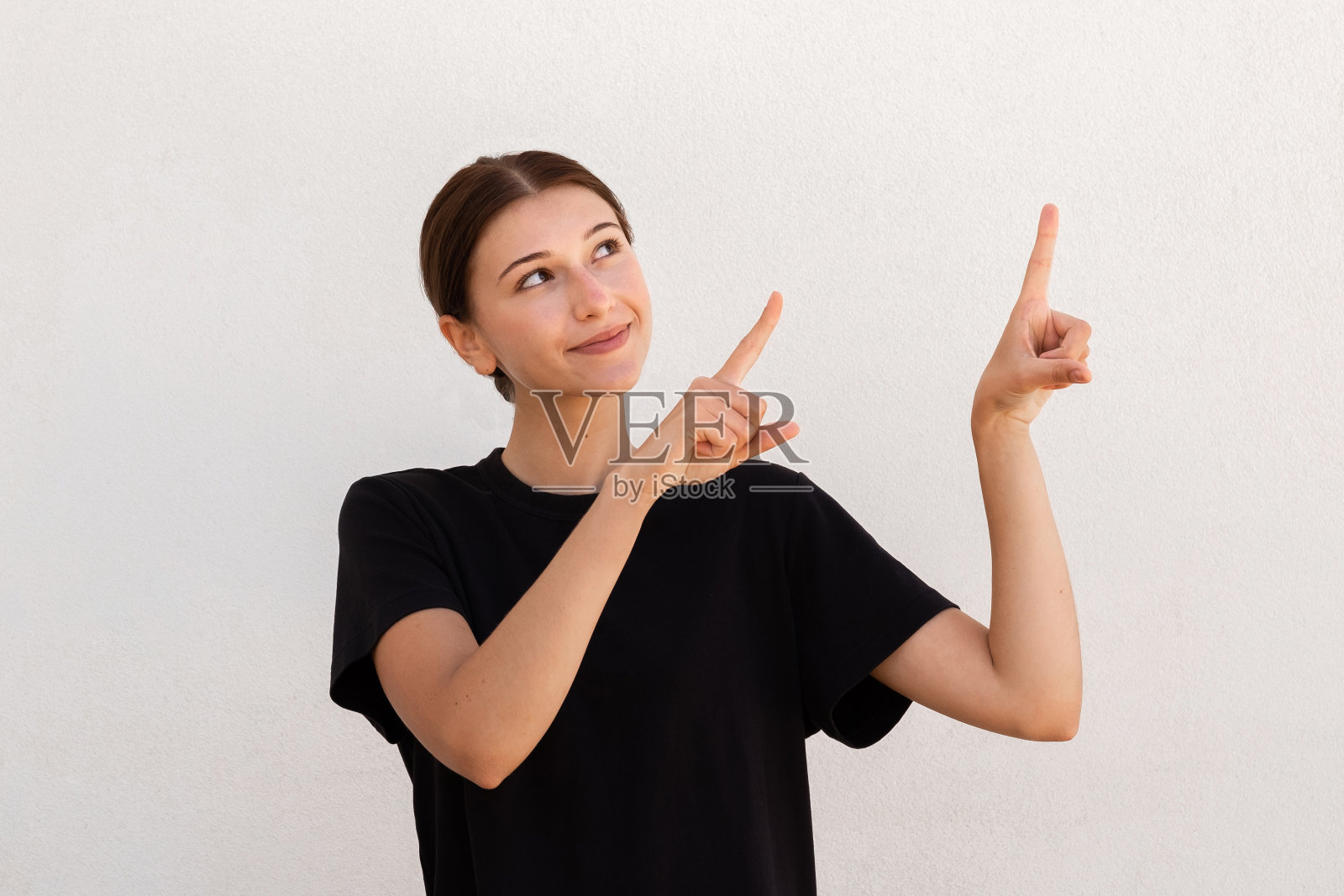 正面年轻女子的肖像指向食指向上照片摄影图片