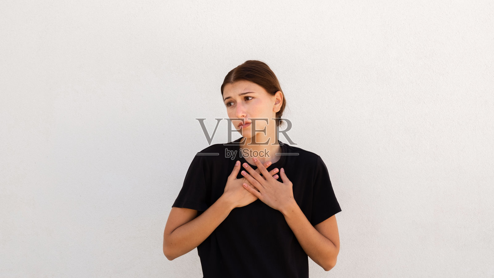 懊悔的年轻女子摸着自己的胸部照片摄影图片